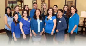 Several staff and caregivers in the hallway of Villa Las Palmas